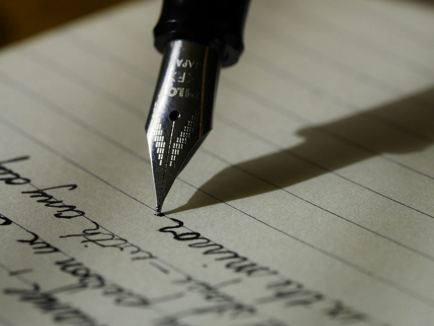 A fountain pen writing on a page of paper A fountain pen writing on a page of paper