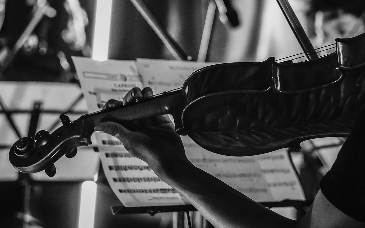 Person playing violin in orchestra