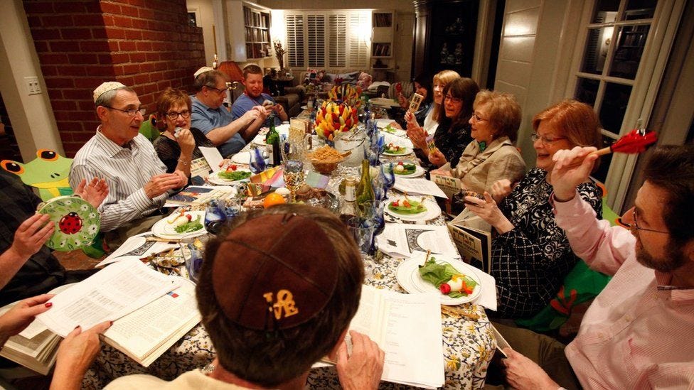 People sit around a long table for a Passover seder