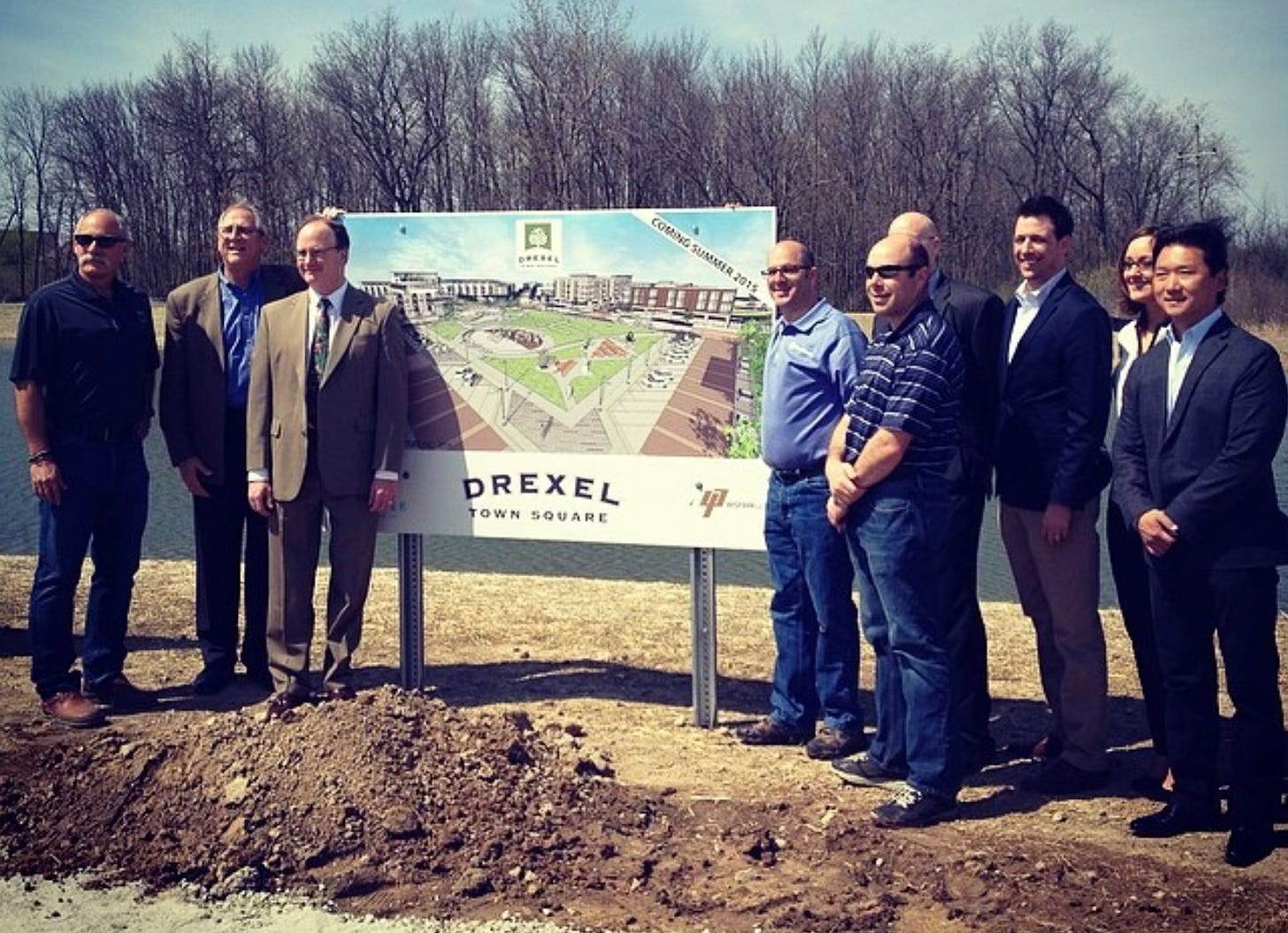men standing next to sign at Drexel Town Square groundbreaking event