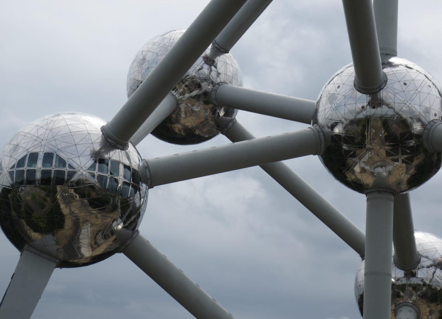 Fotografia di un particolare di una struttura composta da sfere metalliche e sbarre che le collegano, simile a come vengono rappresentati atomi e molecole in fisica e chimica Fotografia di un particolare di una struttura composta da sfere metalliche e sbarre che le collegano, simile a come vengono rappresentati atomi e molecole in fisica e chimica