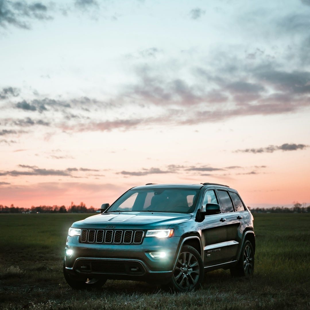 gray bmw x 6 on green grass field during sunset gray bmw x 6 on green grass field during sunset