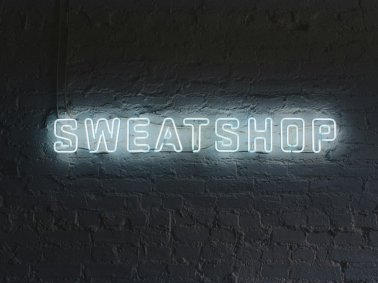 turned on white Sweatshop neon signage