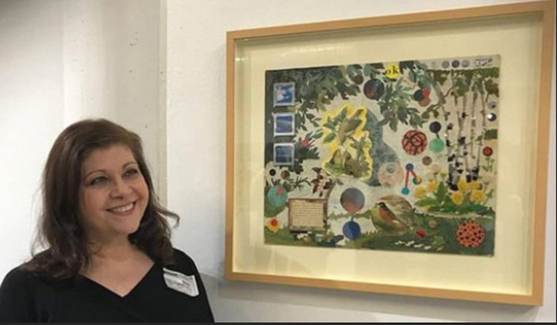 Marsha Glickman standing next to one of her framed collages.