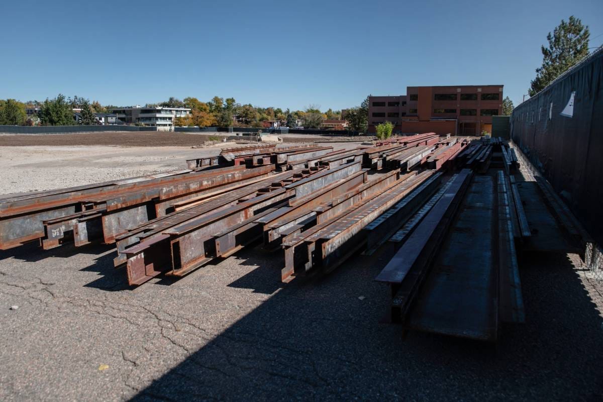 Steel beams are piled together on a vacant lot