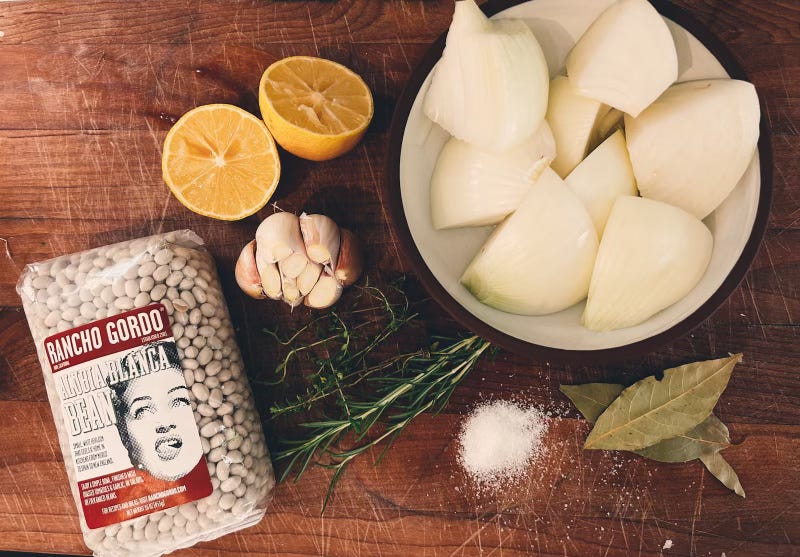 Rancho Gordo’s Alubia Blanca dried beans, garlic, halved lemon, quartered onions, fresh rosemary salt, bay leaves
