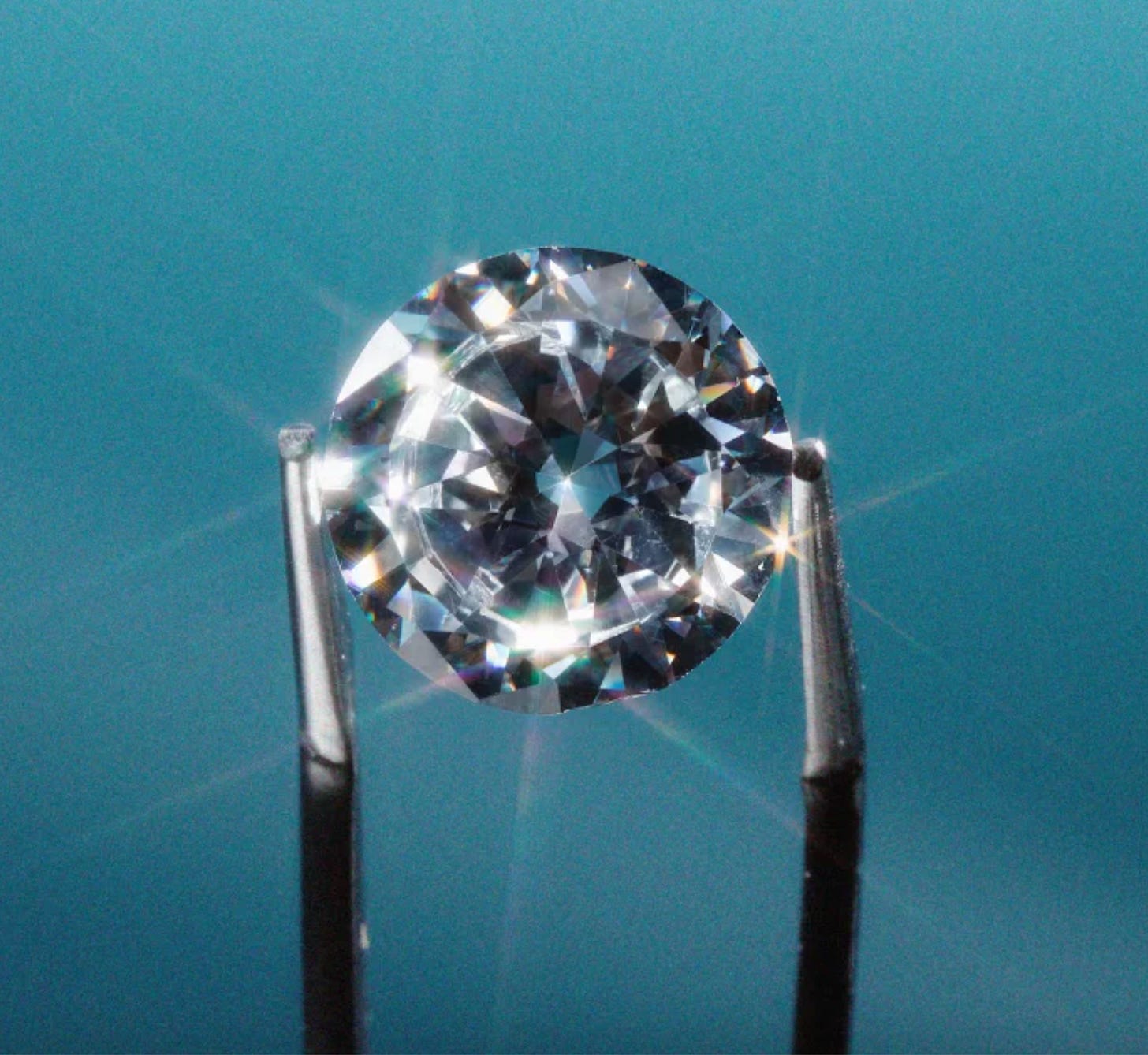 A photo of a super sparkly diamond being held up with tweezers.