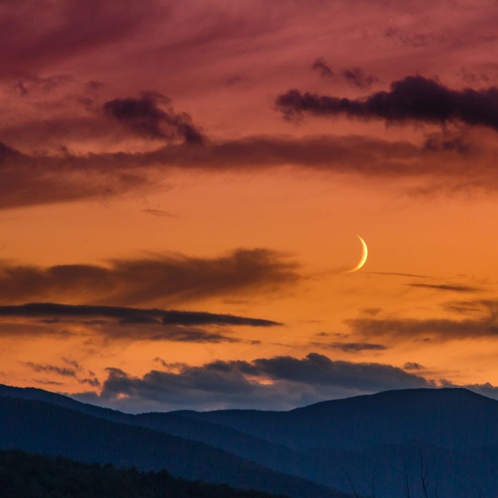 crescent moon in orange night sky