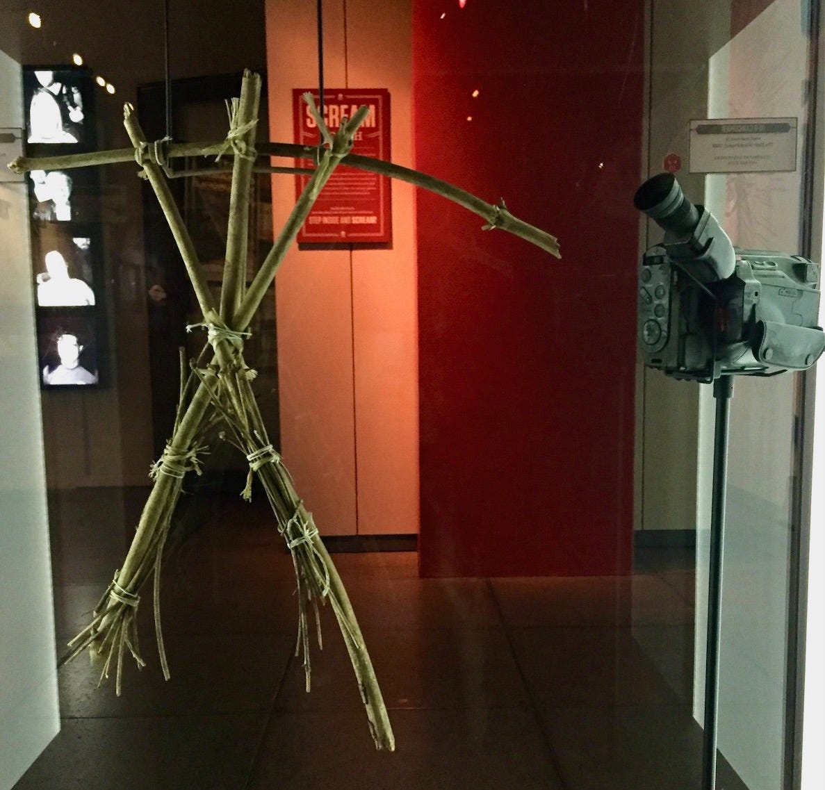 The iconic Blair Witch stick figure prop on display beside a video camera