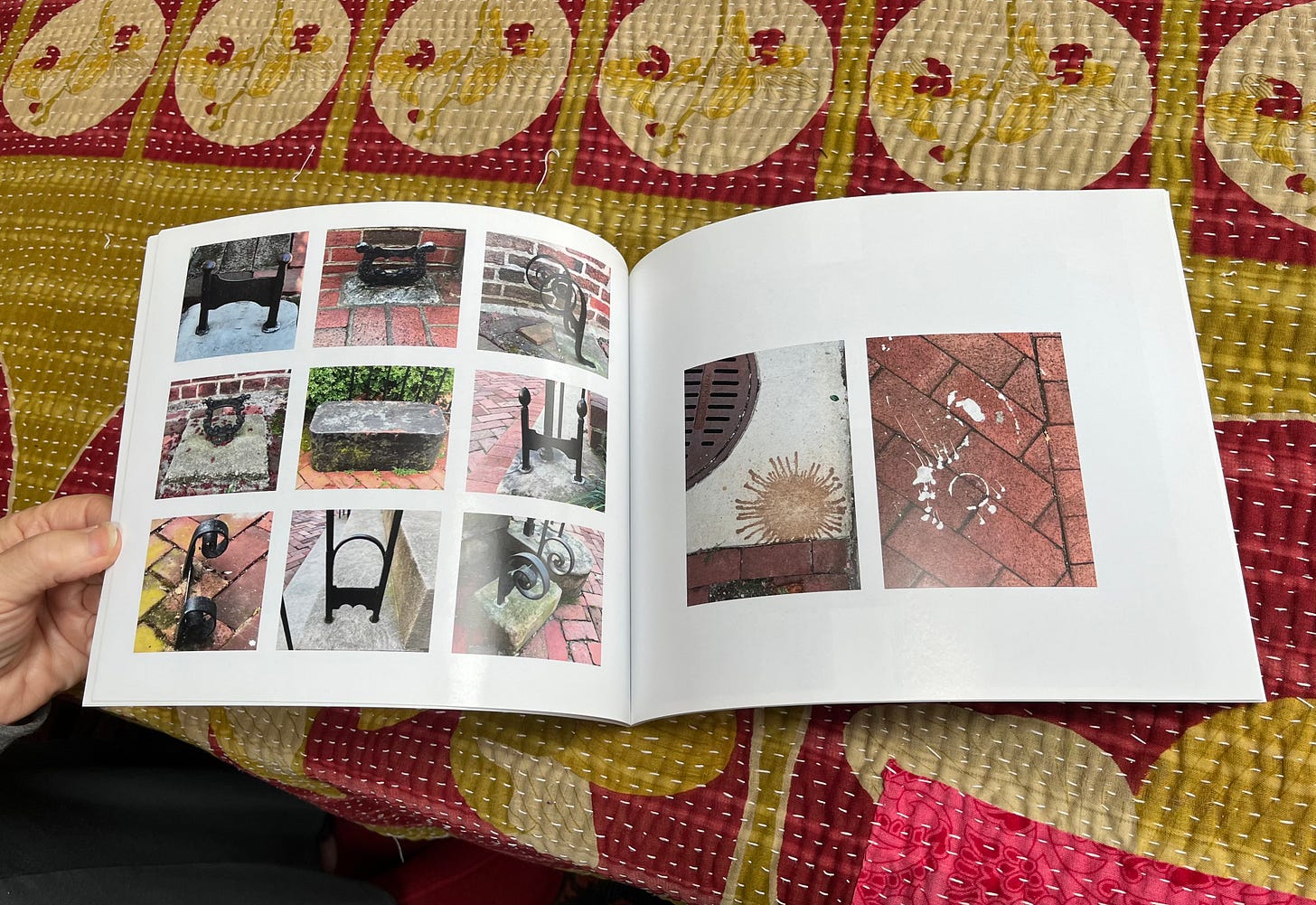 The interior pages of a photo book, showing splattered paint on the sidewalk and ironwork.