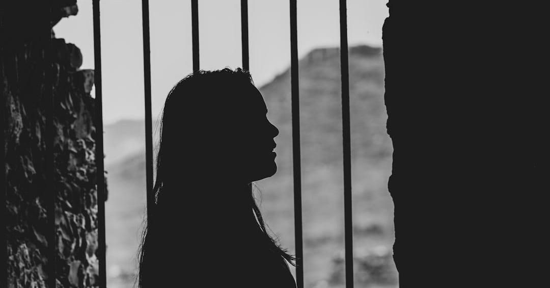 shadow of woman by the metal bar window