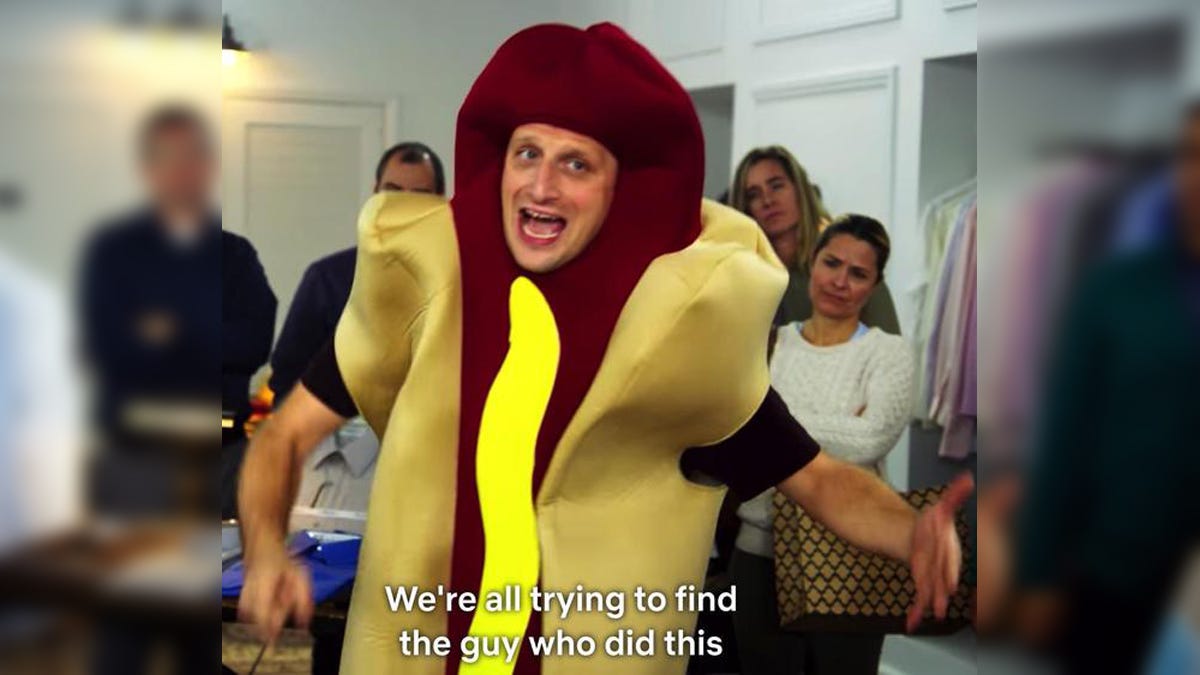 a white man in a hot dog suit among a throng of shoppers in a high end menswear shop, caption "We're all trying to find the guy who did this"