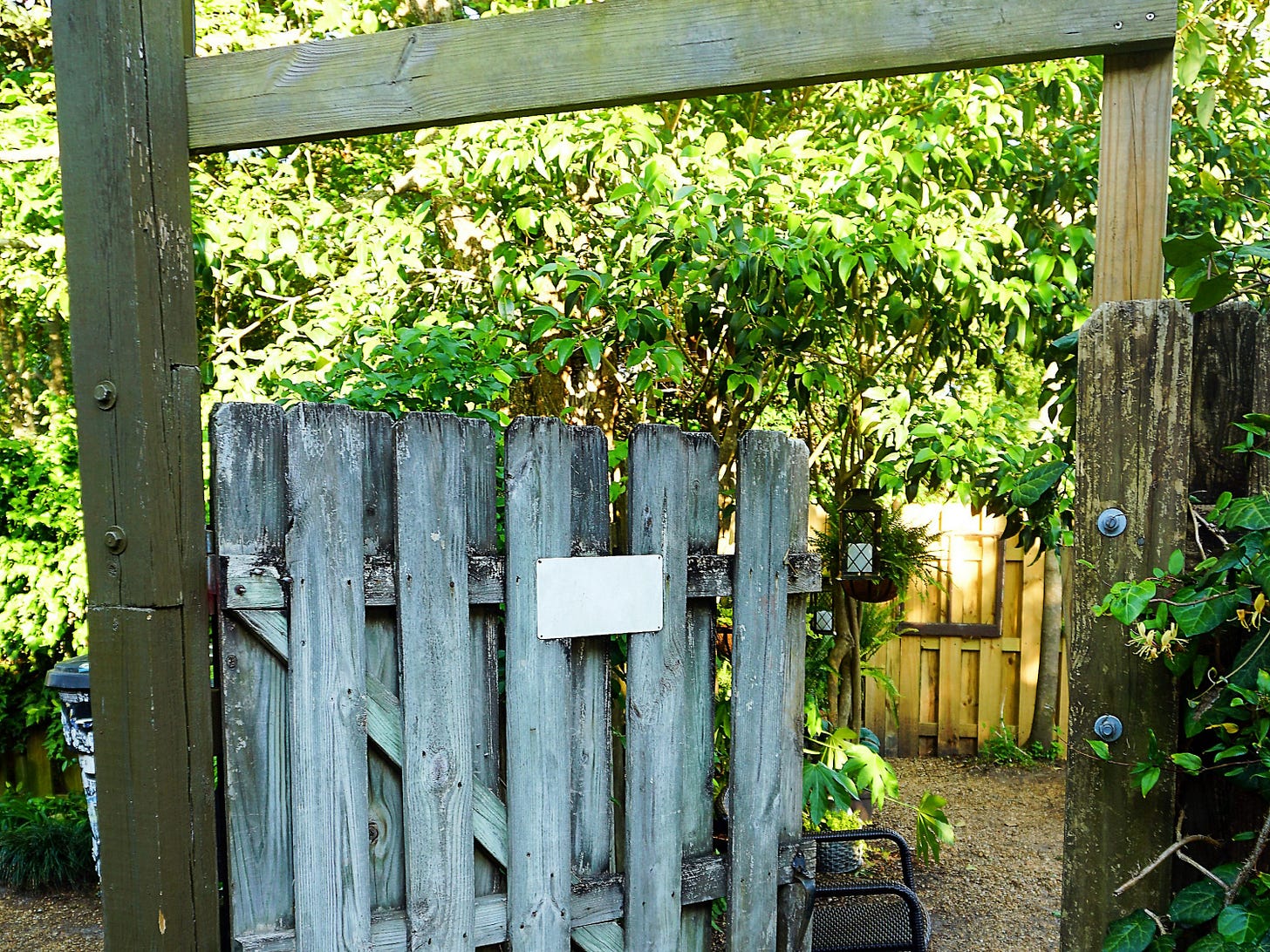 a wooden gate with a sign on it