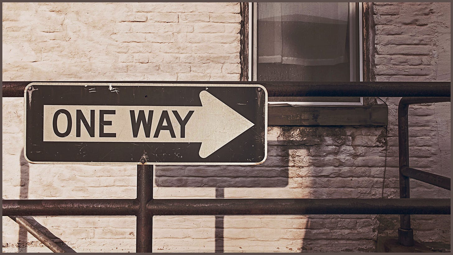 one way sign posted in front of delapidated building. Sepia tone.