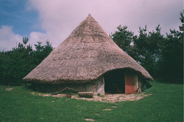 Romano-British roundhouse: wattle & daub walls, thatched roof.