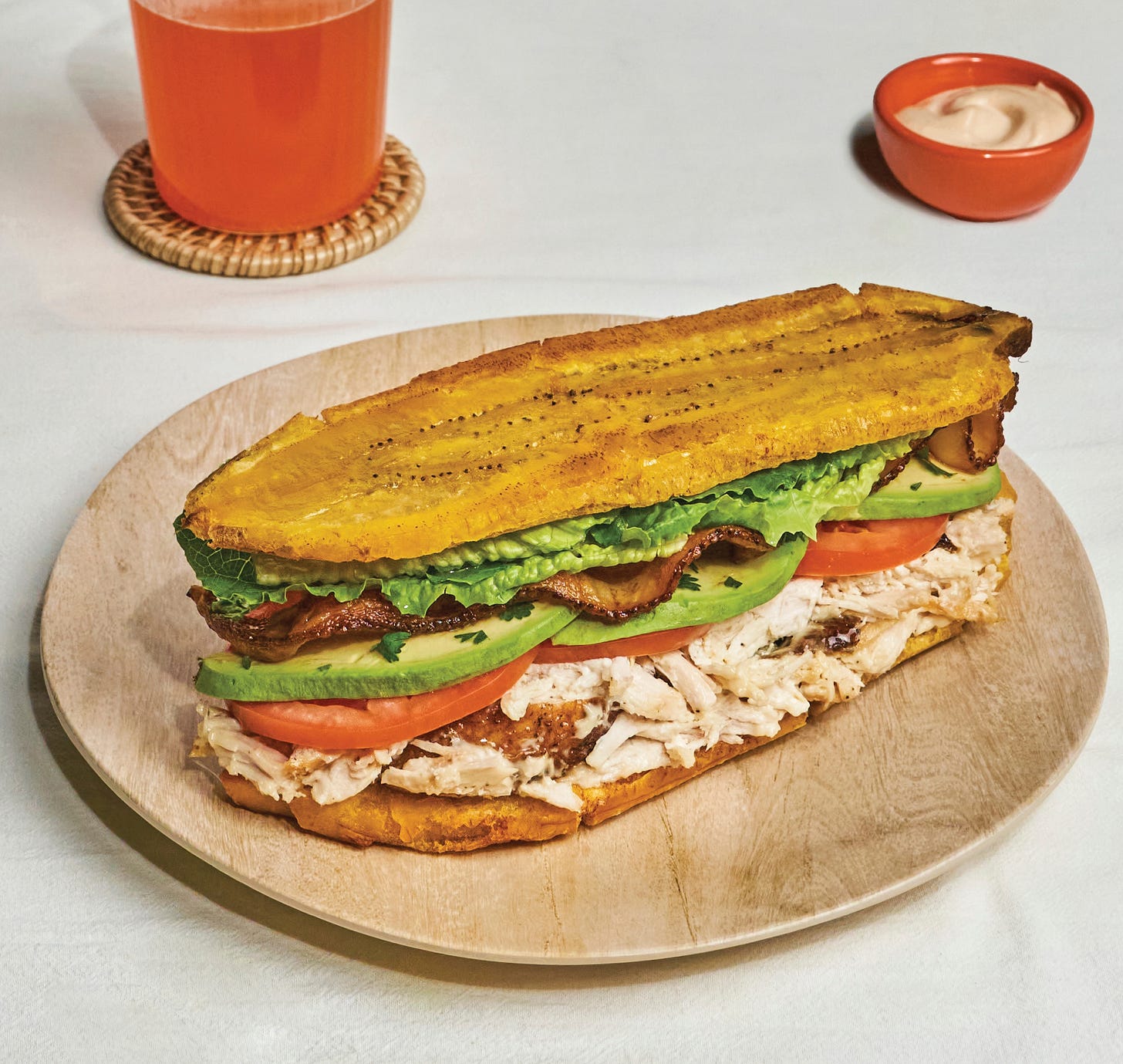 Chicken jibarito BLT with crispy plantains as bread on a plate.