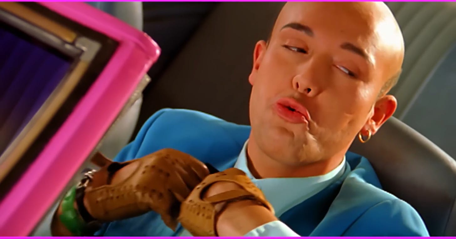 Still from the music video for Aqua's "Barbie Girl": Ken adjusting his collar in the car