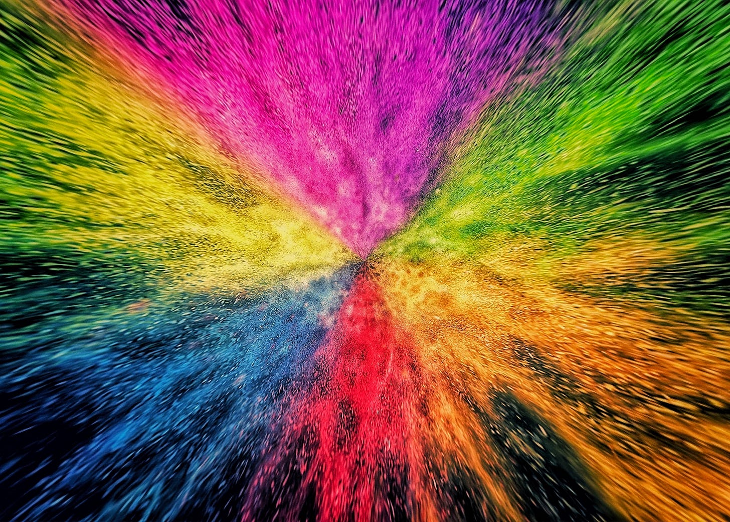 An explosion of scattered colorful particles of light on a dark background