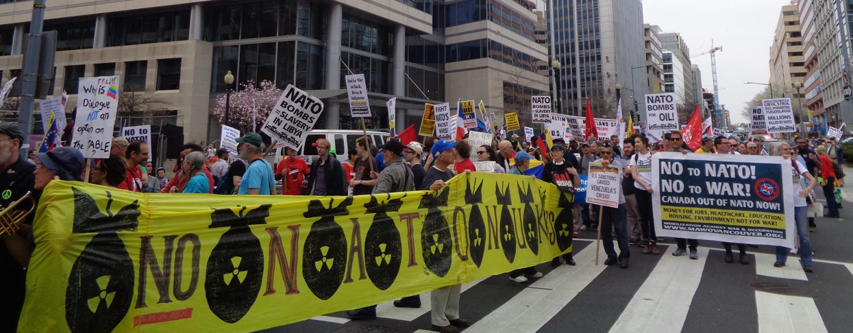 Protesters march through Washington DC, carrying a banner that reads No NATO Nukes