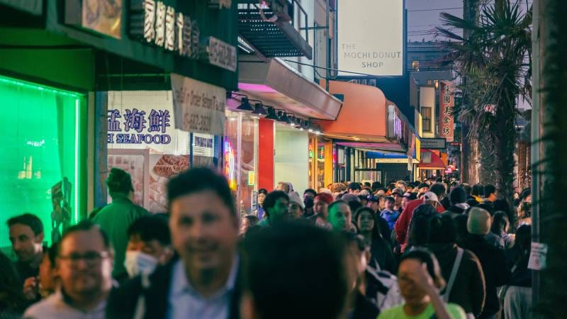 Crowded nighttime street scene at a San Francisco night market.