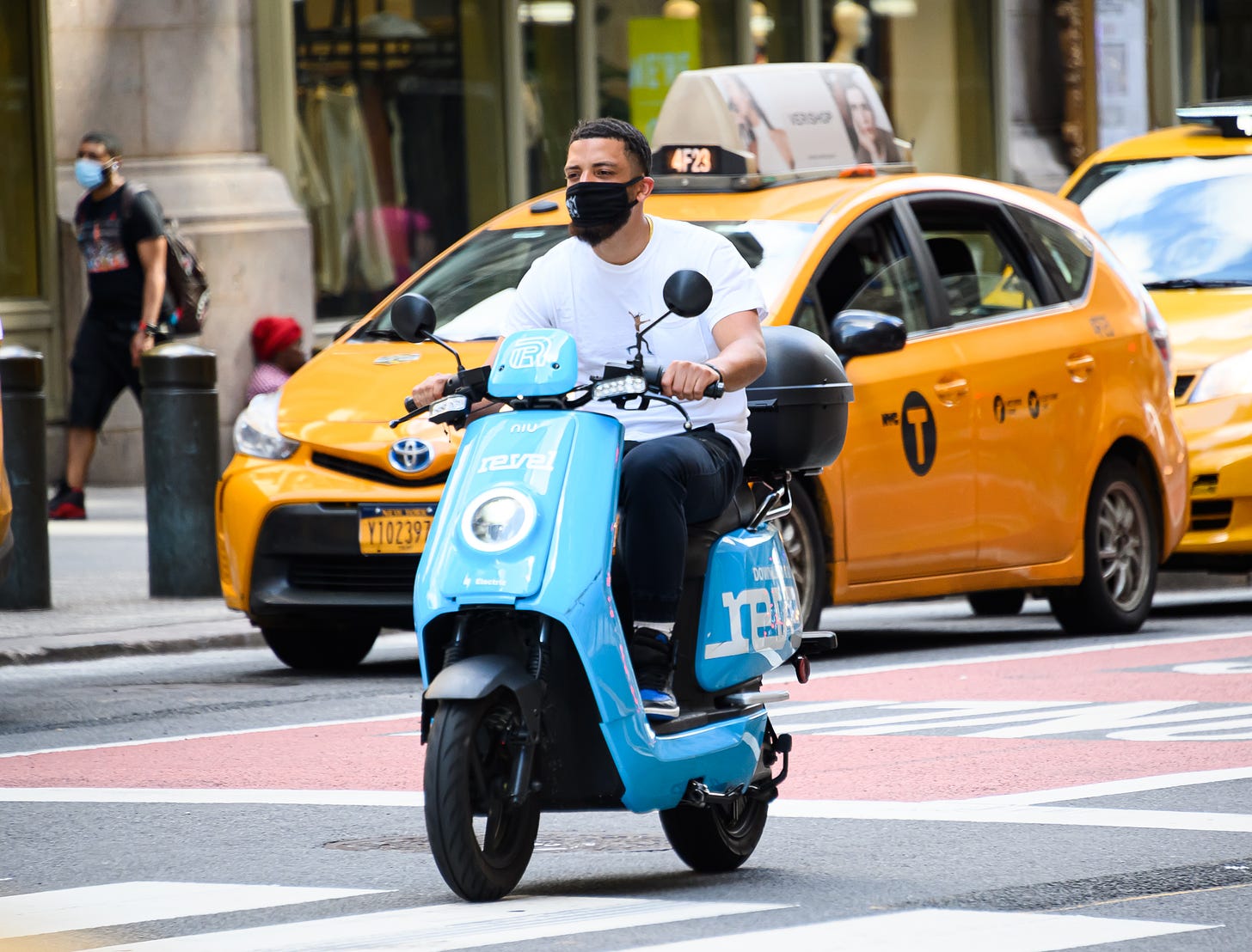 A man rides a Revel moped through Manhattan in 2020.