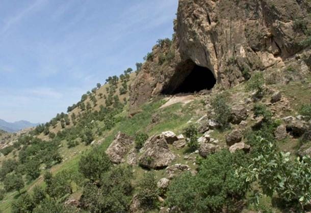 Vista del exterior de la cueva Shanidar, 2005. En su interior se encontró un colgante de cobre. Observe a escala los dos hombres agachados frente a la cueva. (JosephV / CC BY-SA 3.0)