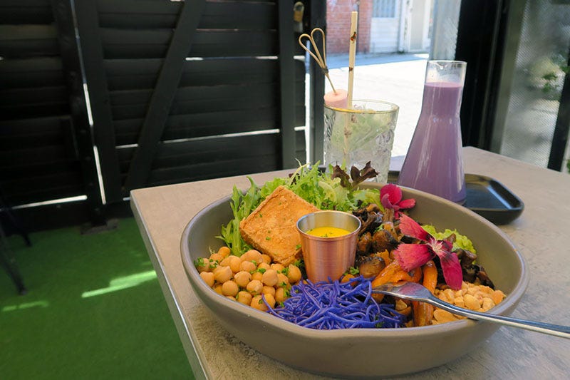 A very colourful buddha bowl and glass of iced taro with fairy floss at Brighton Soul in Melbourne.