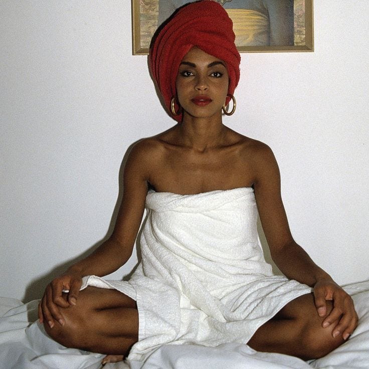 This may contain: a woman in a towel sitting on a bed This may contain: a woman in a towel sitting on a bed