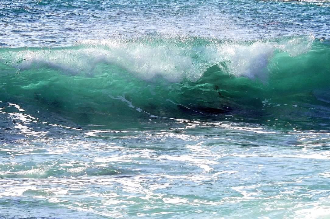 Blue wave cresting in the ocean