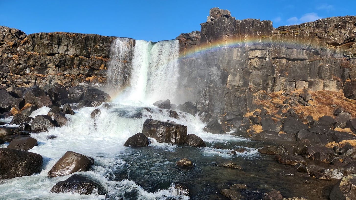 A waterfall with a rainbow in front of it
