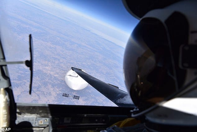 Above, a US Air Force pilot looks down at the first, alleged Chinese spy balloon as it glided over Montana on February 3, 2023. Unlike the smaller UFOs shot down later that month, this device was massive - its balloon was reportedly bigger than Disney's geodesic sphere at Epcot Center