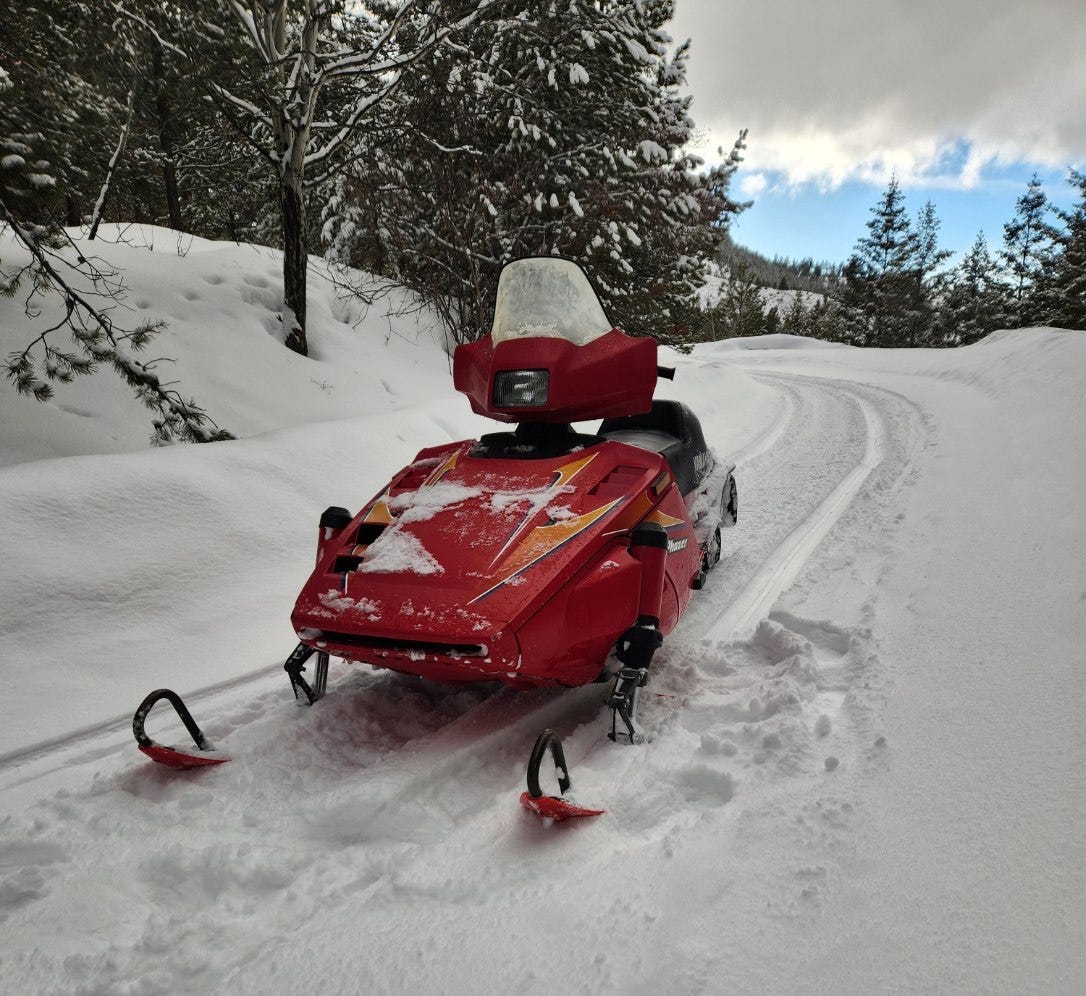 red snowmobile on snowy path