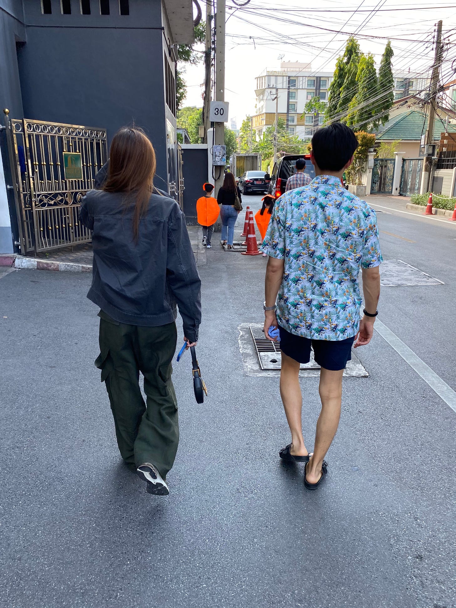 walking on a noisy street behind a hip Japanese couple