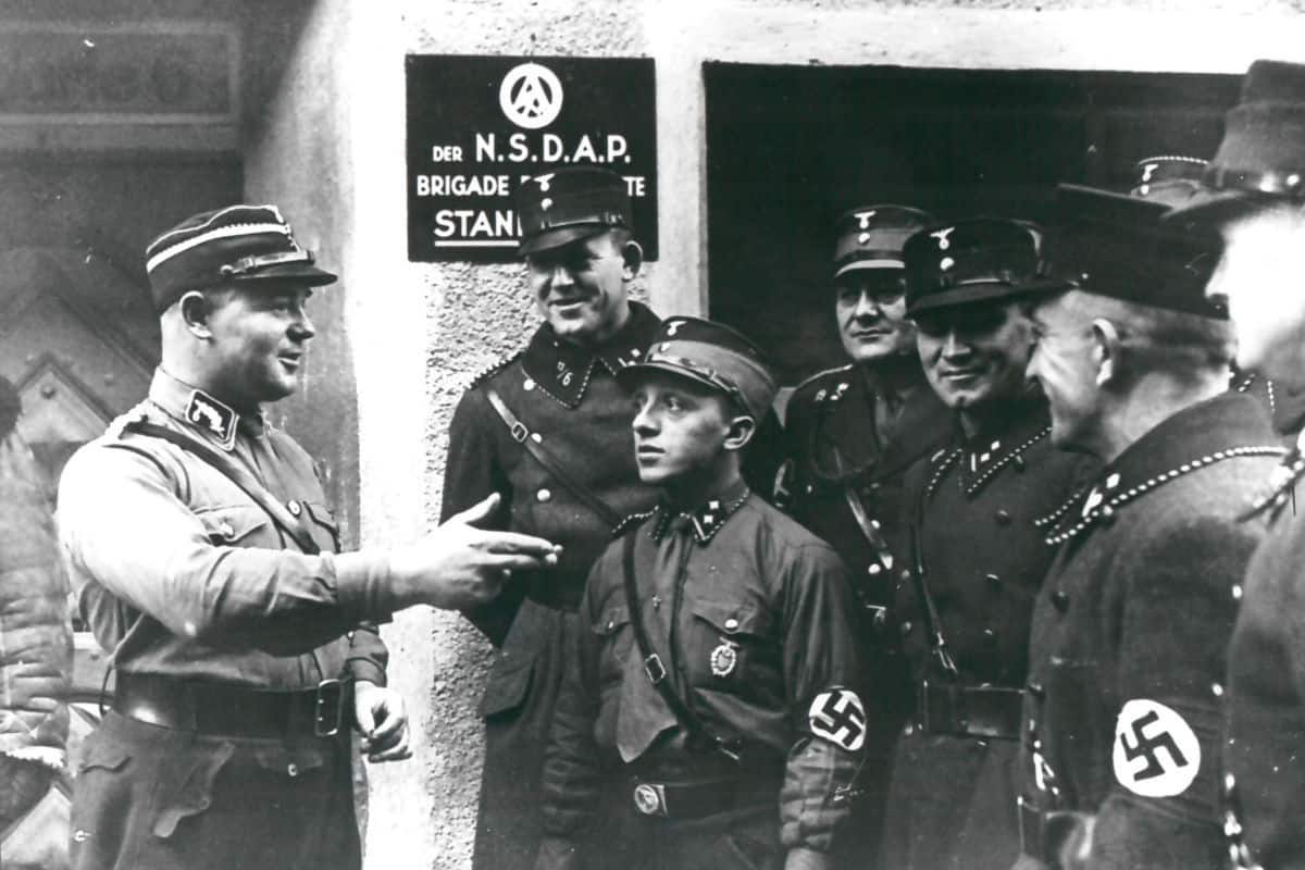 Ernst Röhm was murdered in the event known as the Röhm Putsch, or the Night of Long Knives. As the leader of the SA, Röhm was seen as a threat to Hitler’s power. In this photo, Röhm is talking to a group of SA men, who appear to be listening intently. 