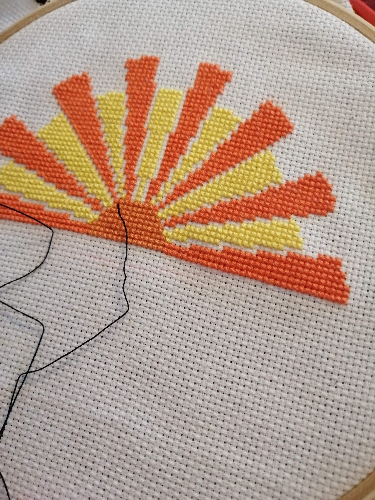 Cross stitch in a hoop with a rising sun from the Edmonds baking logo