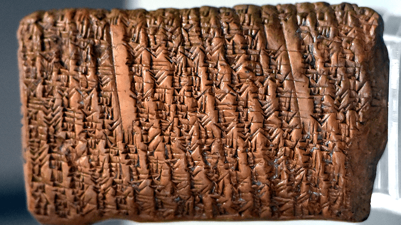 An ancient Babylonian clay tablet covered in writing.