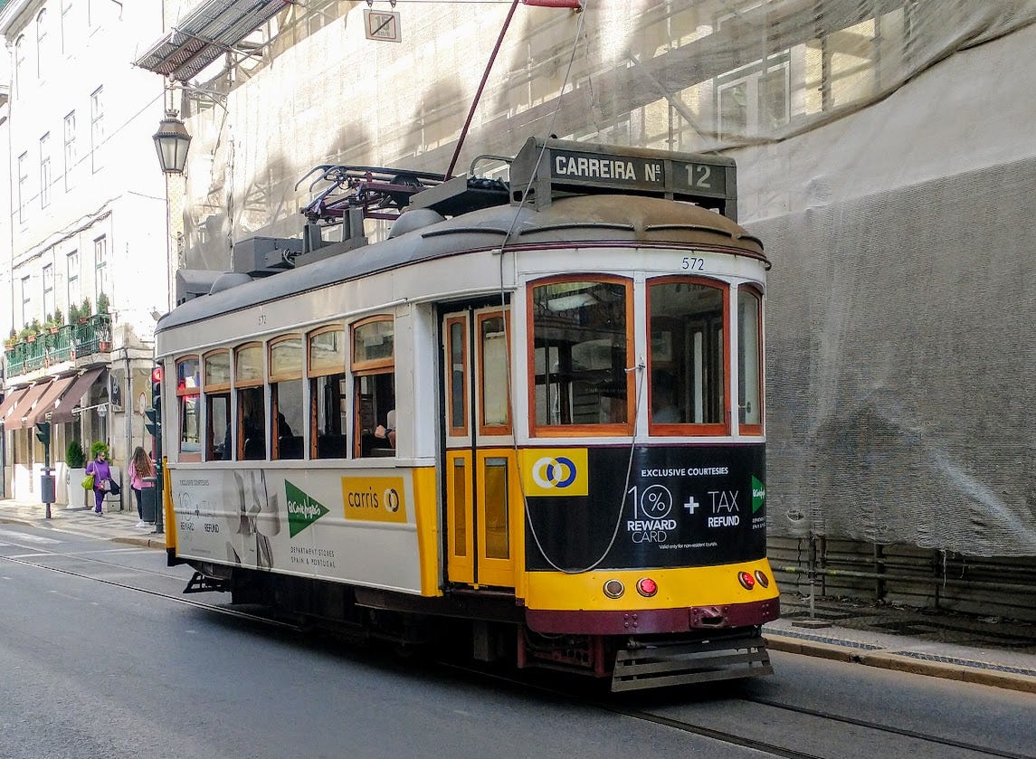 One of Lisbon's iconic yellow trams on a small street in one of the oldest parts of the city.