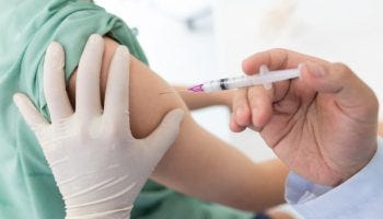 Close up of a Doctor making a vaccination in the shoulder of patient.