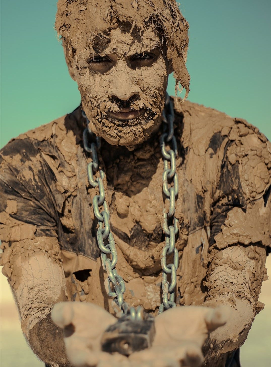 man in brown and black camouflage shirt with white rope on his head