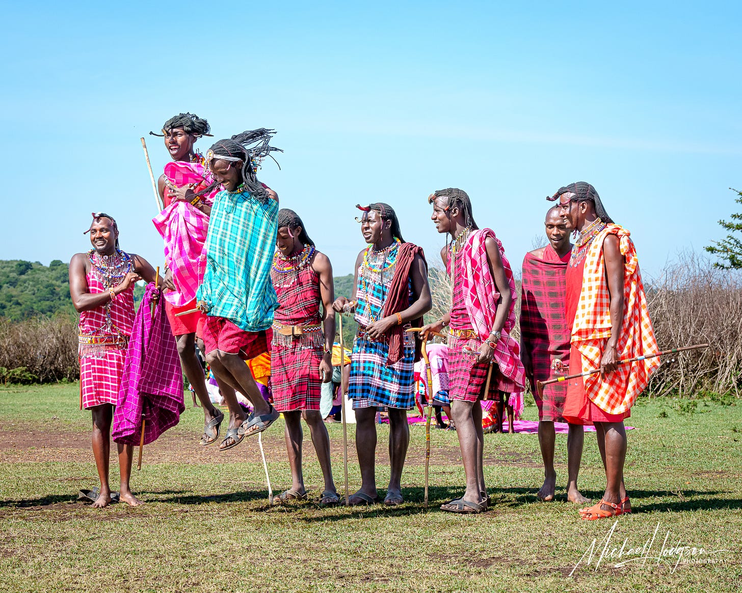 Colorful photo of Maasai warriors performing the jump dance ceremony. 