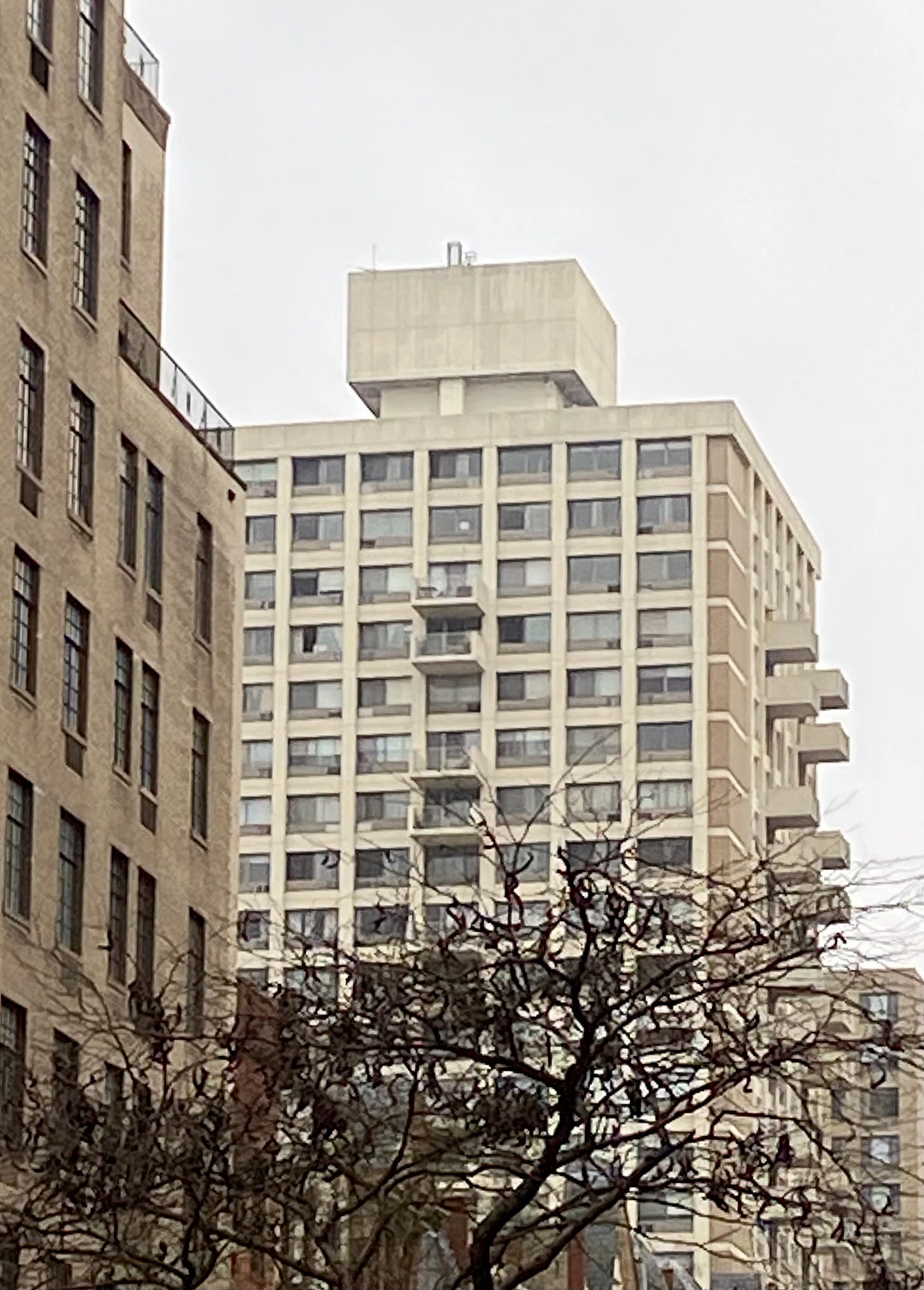 A white box of a building with an an opaque white box on top of it. The effect is a bit like a 1950s robot.