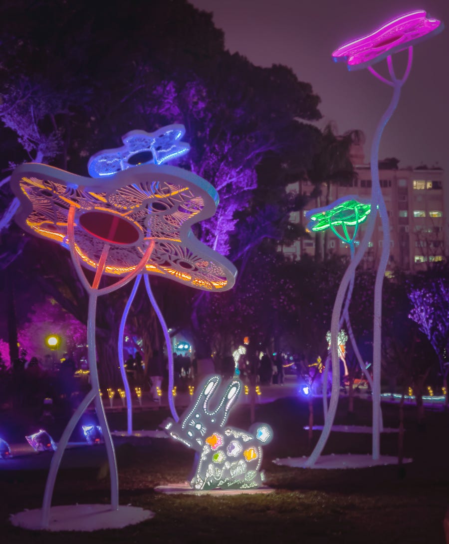 A 2D light-up rabbit sits beneath giant neon-colored flowers at the 2023 Taiwan Lantern Festival