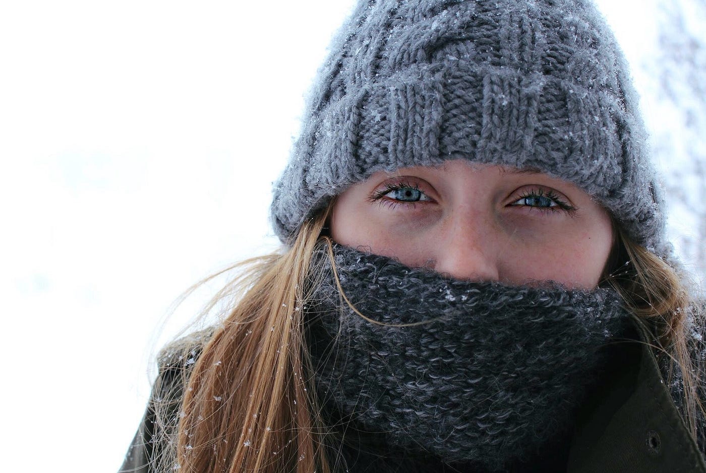 Young woman bundled up in snow, closeup