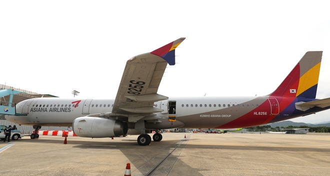 An Asiana Airlines plane is parked as one of the plane's doors suddenly opened at Daegu International Airport in Daegu, South Korea, Friday, May 26, 2023. A passenger opened a door on an Asiana Airlines flight that later landed safely at a South Korean airport Friday, airline and government officials said.