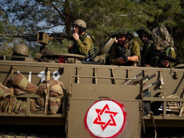 Israeli soldiers drive an armoured personnel carrier (APC) near the border with the Gaza Strip, in southern Israel, Sunday, Oct. 22, 2023. (AP Photo/Ariel Schalit)