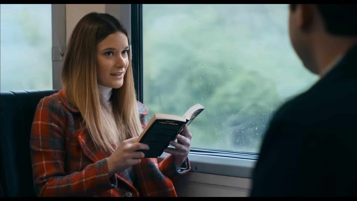 Sonya in the movie reading a book on a train.