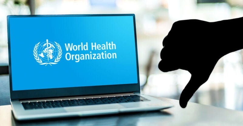 world health organization on laptop with thumbs down on top