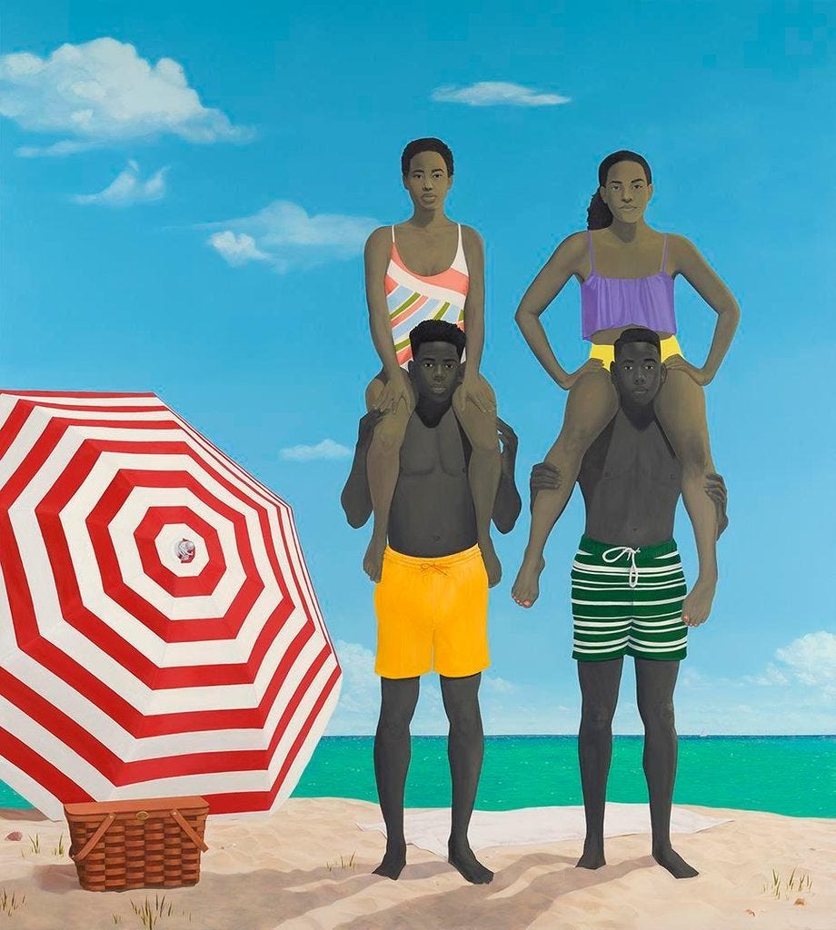 Four African-American teenagers at the beach with two girls sitting on the shoulders of two boys