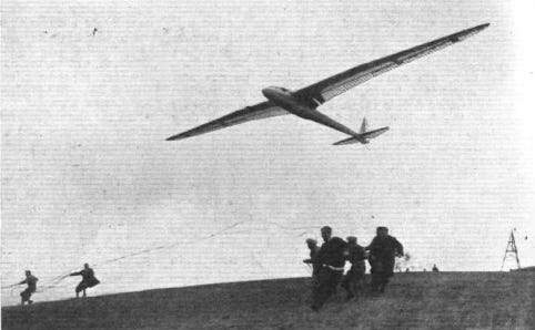 Sailplane liftoff with ground crew releasing tow ropes