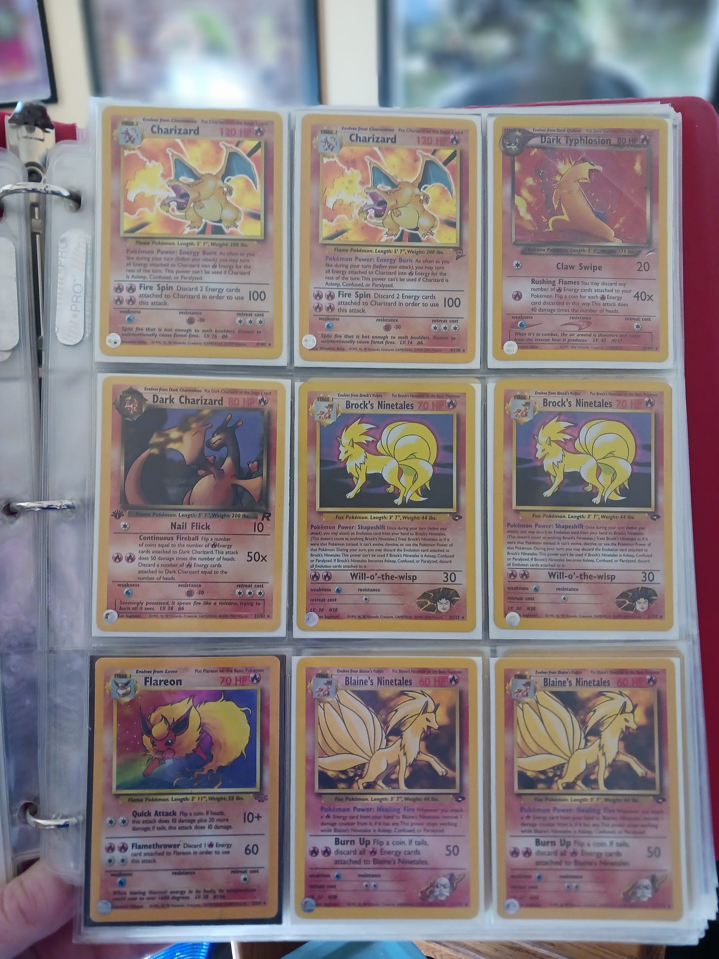 A page of Ryan’s binder of Pokémon cards, featuring powerful fire type Pokémon from the Jungle, Team Rocket, Gym Heroes, Gym Challenge, and Neo Genesis TCG sets.